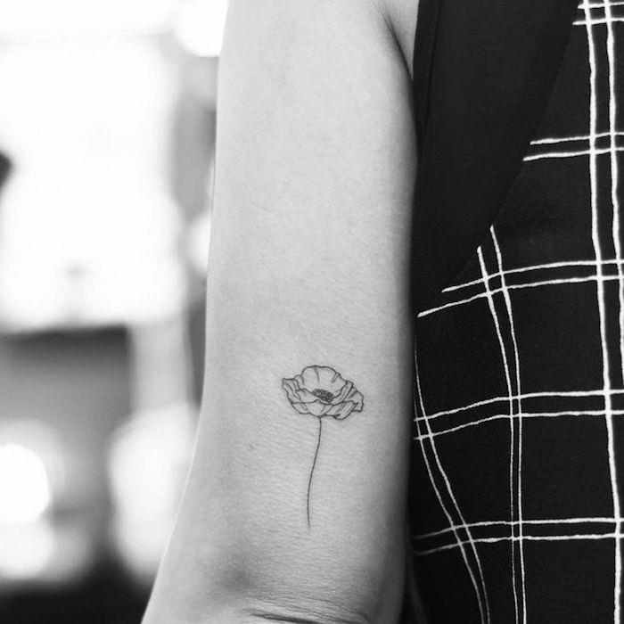 liten vallmotatuering som betyder tatueringsblommor på armbågen