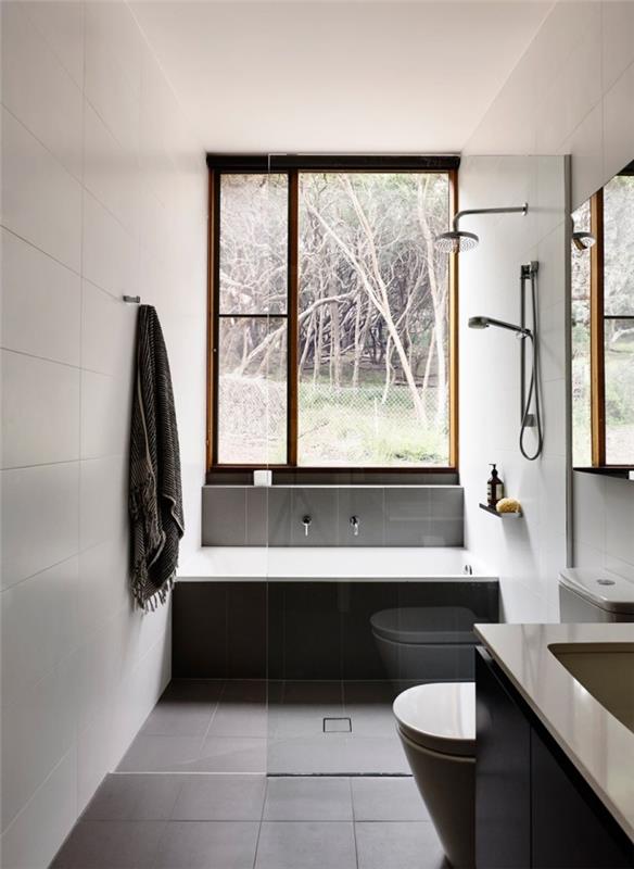 badrumsmodell begränsat utrymme med vita väggar med mörkgrått klinkergolv, liten badkarsmodell