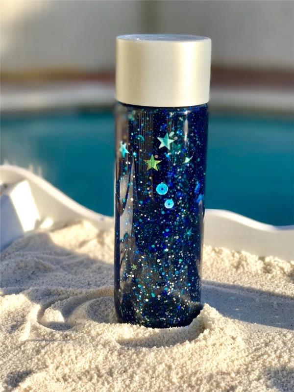 exempel på en montessori-flaska på ett galaxtema, idé hur man fyller en nedkylningsflaska med färgat vatten
