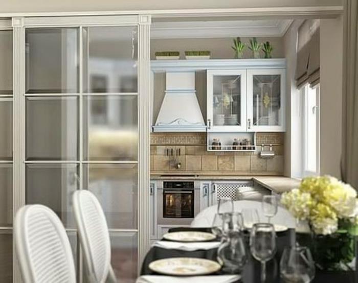 kuchyňa s posuvnou vnútornou sklenenou strechou, bielymi stoličkami a oválnym čiernym stolom