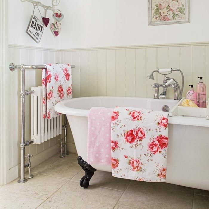 vitt badkar med svarta ben, blommiga tyger, rosa handduk, vintagekran, väggpanel, radiator med handdukshållare, rosa blommemålning, shabby space decor