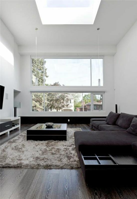 malý-čierny-konferenčný stolík-parketová podlaha-béžovo-sivý-koberec-pohovka-biele-steny-moderná obývačka