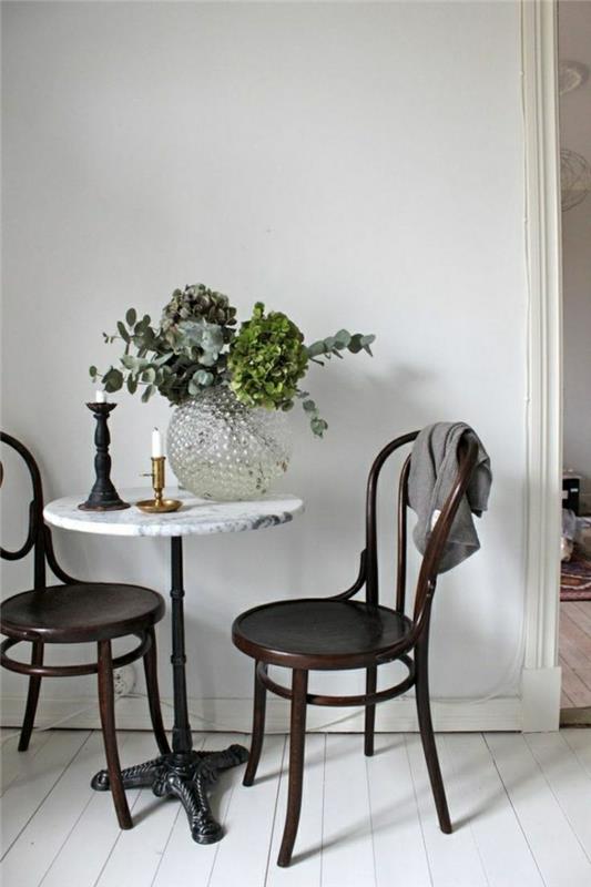 litet-marmor-bord-blommor-på-trä-stol-bord-vitt-golv-