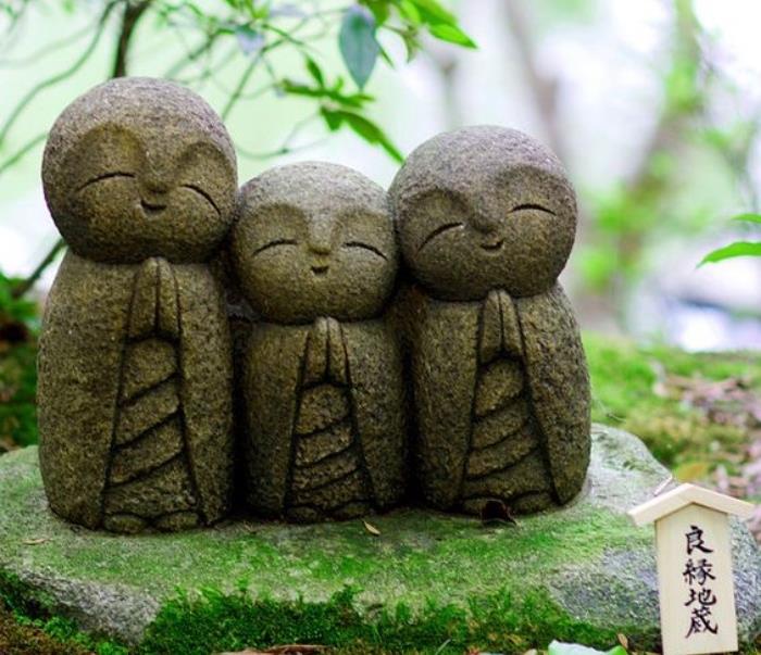 ثلاثة تماثيل يابانية صغيرة تصلي على حجر ، مغطاة بالطحلب ، زينة زن لطيفة