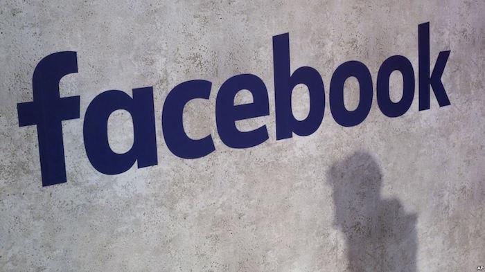 Modré logo na facebooku na vonkajšej stene ilustruje článok Britská správa pre výbor pre falošné správy obvinila FB z digitálnych gangstrov