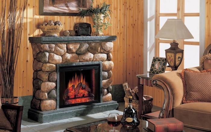 Faux sten falsk eldstad med elektrisk falsk eld skärm i vardagsrum med chalet-stil dekoration med trävägg och antika möbler