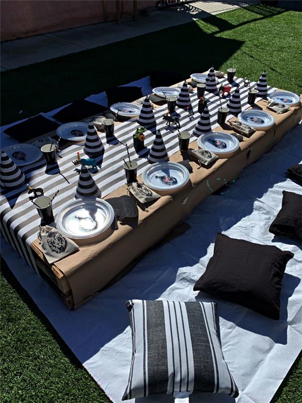 picknickfödelsedagsdekoration, picknickborddekoration i pall täckt med beige bordsduk och randig bordslöpare