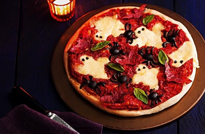 ľahký strašidelný recept na halloweensku pizzu so syrom, paradajkovou omáčkou, salámou a olivami, halloween pizzu s duchmi z taveného syra a olivovými pavúkmi