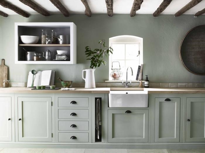 ديكور المطبخ بجدران مطلية باللون الأخضر الحكيم مع سقف أبيض وخشب وأثاث مطبخ باللون الأخضر الفاتح