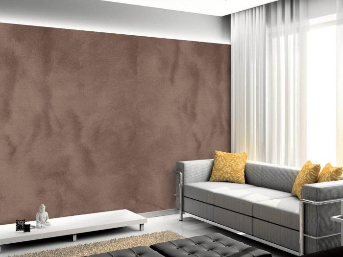 relaxačná atmosféra v šedej obývačke s pieskovou textúrovanou stenou, trendová piesková farba s nápadom zemitého tieňa