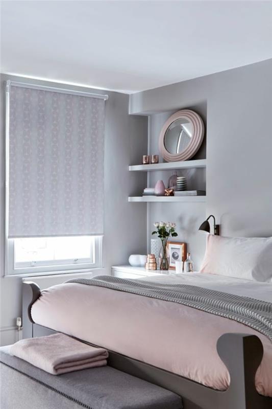 بطانية سرير باللون الوردي الفاتح ، طلاء جدران رمادي ، أرفف ومرآة مستديرة ، الظل بلون ناعم