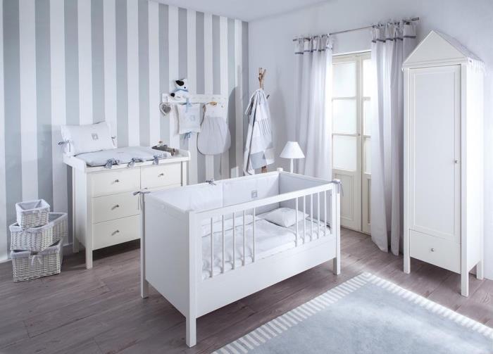 novorodenecká spálňa s bielymi stenami s časťou steny v bielej a svetlo šedej pruhovanej tapete, nábytok z bieleho dreva