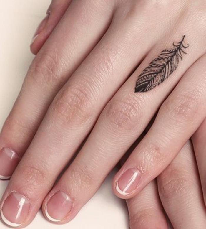 vacker fjäder tatuerad på fingret, en subtil kvinnlig handtatuering