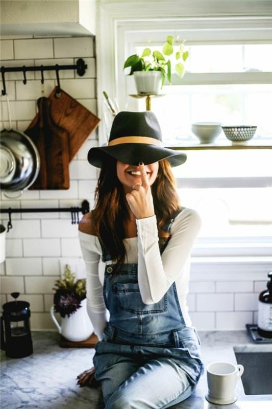 overalls utseende, vitt kök, svart hatt med beige band, vit blus