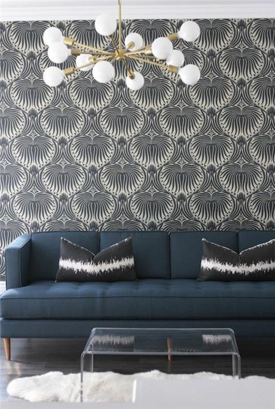 trompe l'oeil tapet med påfågelstjärtmönster, armatur med flera kulor i mattvitt glas, soffa i indigoblått, vitt plastbord, vit matta imiterad djurhud