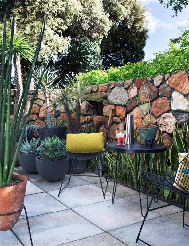nápad upravenej záhrady s odpočinkovým nábytkom, exotické zelené rastliny pre malú záhradu s podložkou
