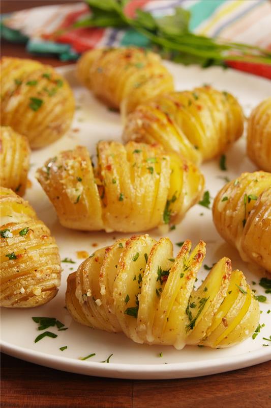 skivad potatis, med örter ovanpå, i en vit tallrik, veganska superbowl -snacks