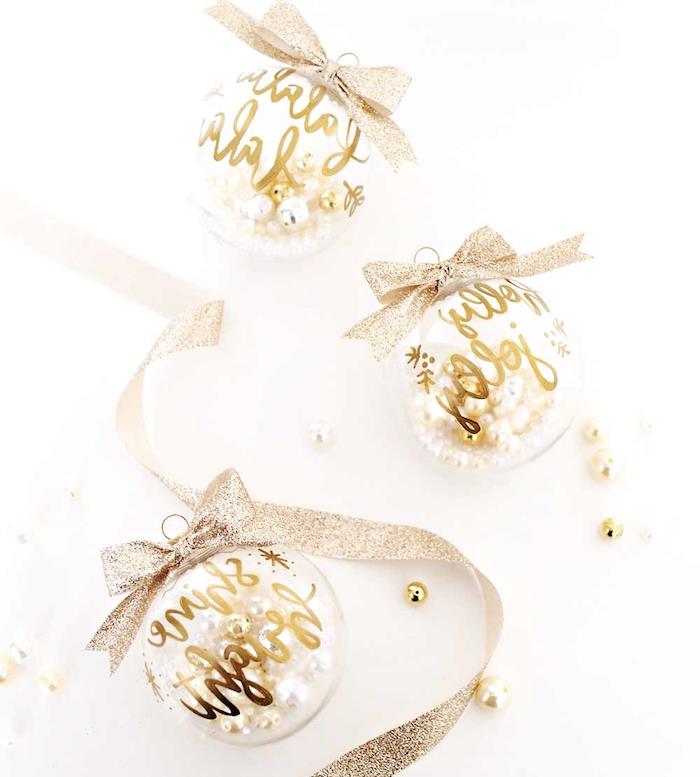 originálna vianočná ozdoba v priehľadných vianočných guličkách zlatý text a trblietavá stuha, guľa plnená elegantnými perlami