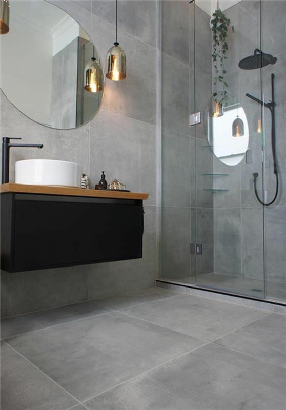 pärlgrått badrum med italiensk dusch med stor rund spegel och armatur ovanför