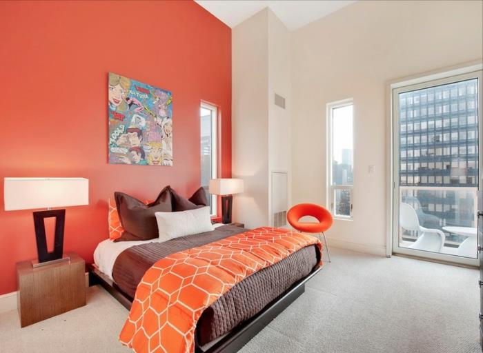 لون مثالي لغرفة نوم البالغين ، جدار مطلي باللون البرتقالي ، طاولتان خشبيتان بجانب السرير ، مصابيح بجانب السرير ، لوحة تجريدية