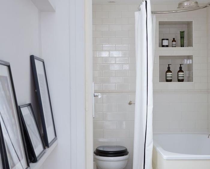 malá biela dekorácia do kúpelne s bielou vaňou, výklenkom na uloženie na stenu, čiernobielou toaletou a grafickým rámovým dekorom