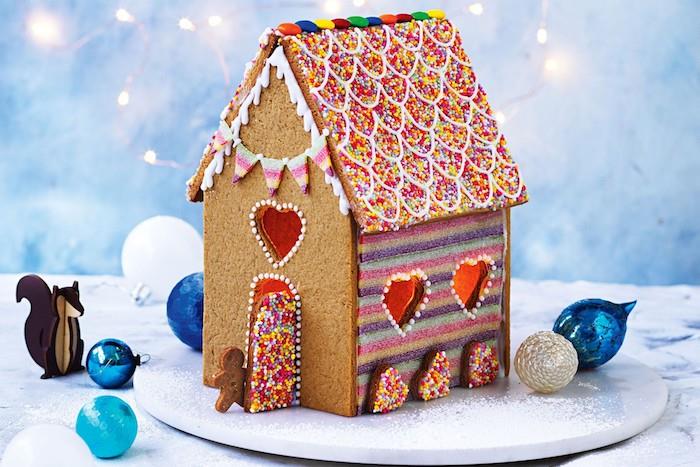 gourmet jul ingefära hus med tak dekorerat med färgglada strössel, färgglada randig vägg och strö hållare