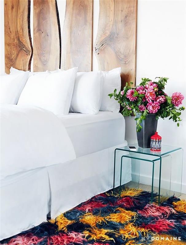 hur man gör sänggavel av träplankor, vita sängkläder, färgglad matta och blombukett i en vas