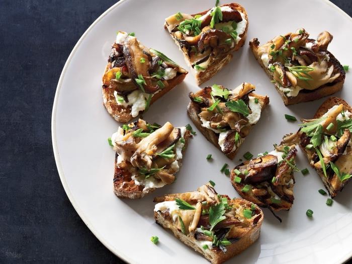 originálny vegetariánsky recept na bruschetta s lesnými hubami na cesnaku, posypaný petržlenovou vňaťou pre ľahký a lahodný aperitív, grilovaný ricotta toast ozdobený lesnými hubami a čerstvými bylinkami