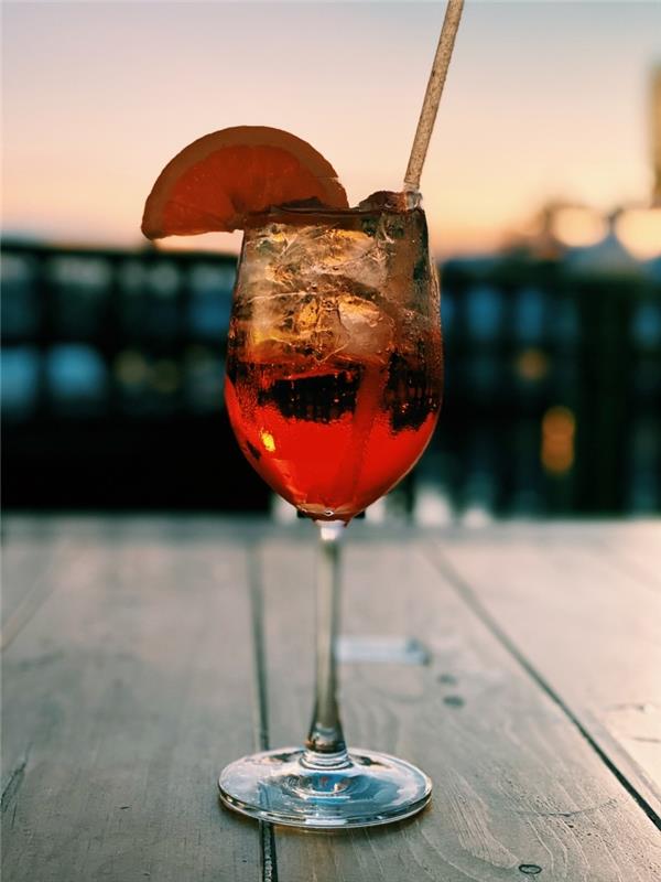 recept spritz glas aperol spritz citronskiva solnedgång sommar träbord