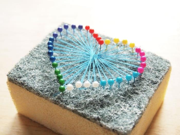 DIY model ozdobného predmetu vyrobený so špongiou a špendlíkmi rôznych farieb, jednoduchá ručná činnosť so šijacím vláknom