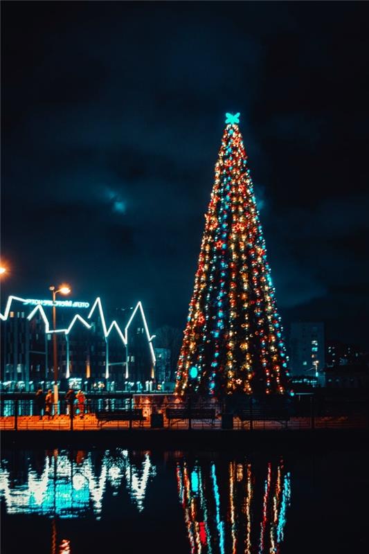 låsskärm tapetidé till jul med ett nattfoto, julgransfoto dekorerat i blått och guldprydnader