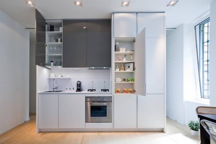 malý kuchynský dekor v bielej a šedej farbe so svetlou drevenou podlahou, myšlienka otvorenej kuchyne na dĺžku