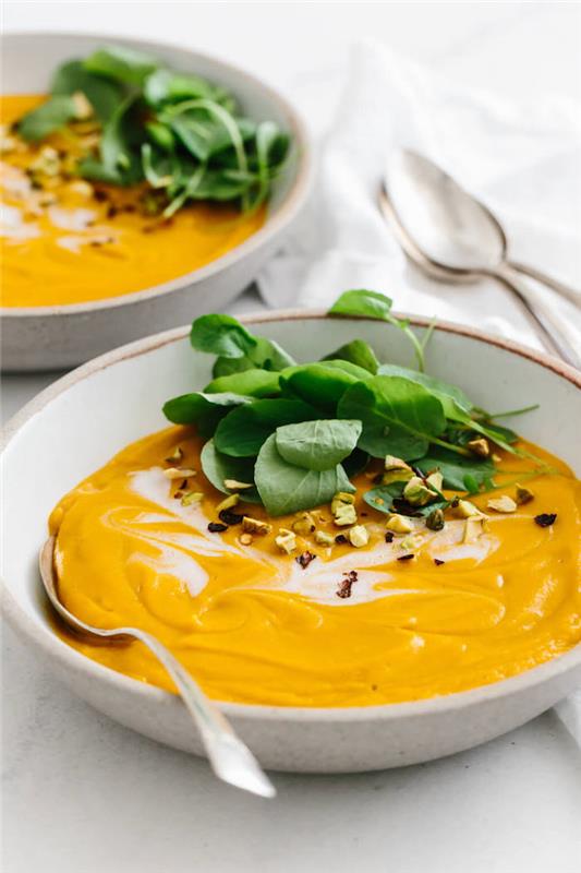 Vellutata di verdure miste ، piatto con vellutata e foglie di spinaci ، piatto tondo con cucchiaio