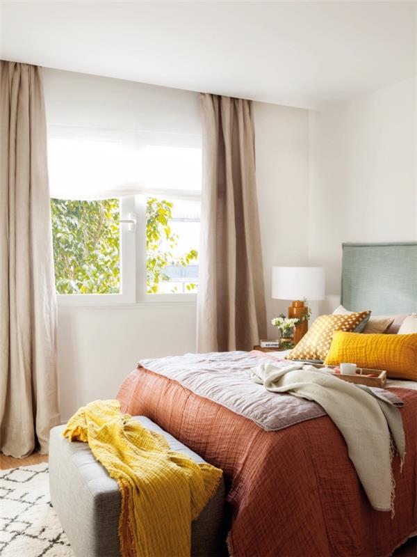 nápad so žltým dekoratívnym predmetom v ženskej spálni, model postele s čelom zelenej mäty, bielou nočnou lampou a tmavým drevom
