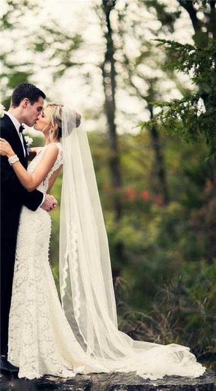 pekné čipkované svadobné šaty spojené s dlhým svadobným závojom s čipkovým lemovaním