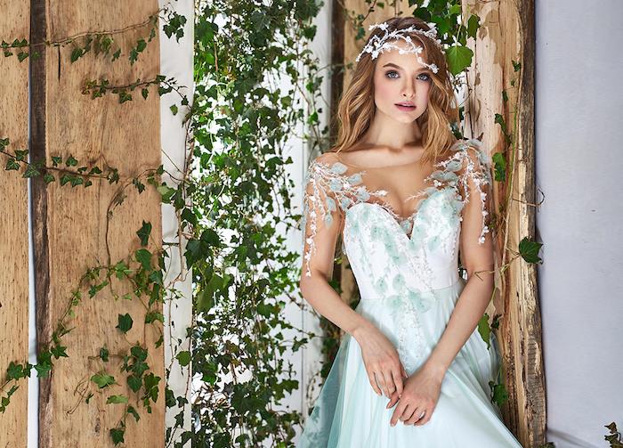 مثال على فستان زفاف الأميرة مع حمالة بيضاء مزينة بأوراق خضراء وتنورة خضراء ، على الطراز الريفي