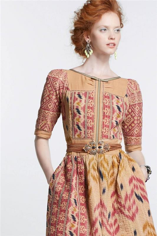 en vintage etnisk look, tryckt klänning i varma nyanser med juvelbälte
