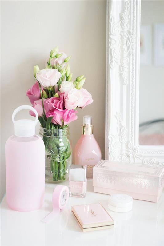 skönhetshörna i ett kvinnligt sovrum, dekorativa föremål i vitt och pastellrosa, bukett rosor