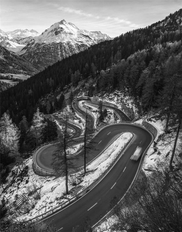 en slingrande väg som slingrar sig genom det schweiziska berget, vackert bergslandskap på vintern