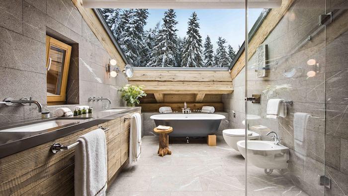 Magnifik utsikt över ett designbadrum i en chalet, rustikt badkar och handfat
