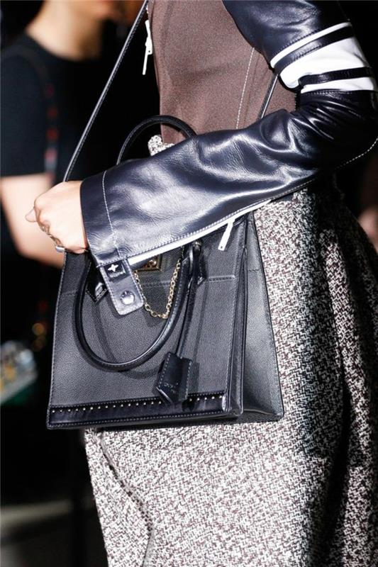 vintage ryggsäck i svart i rektangulär form med logotyp och liten dekorativ kedja i silverfärgad metallskapande av Louis Vuitton