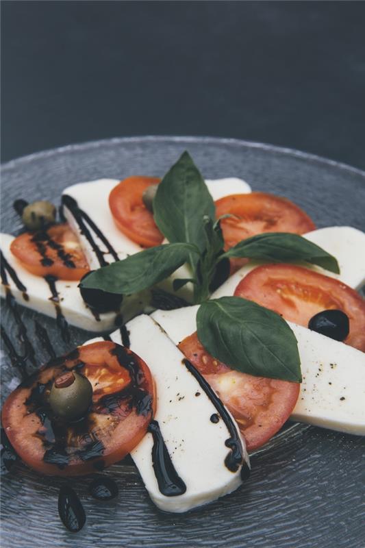 šalát caprese s mozzarellou s plátkami paradajkovej bazalky a balzamikovým octom redukcia