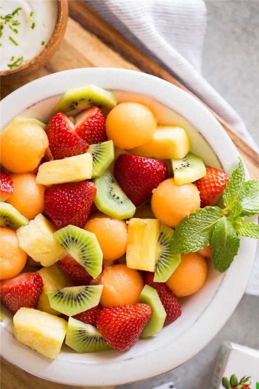 vychutnajte si letné ovocie a pripravte si letný šalát z melónových guľôčok, jahôd, kivi a ananásu, oblečený v kokosovej a citrónovej omáčke