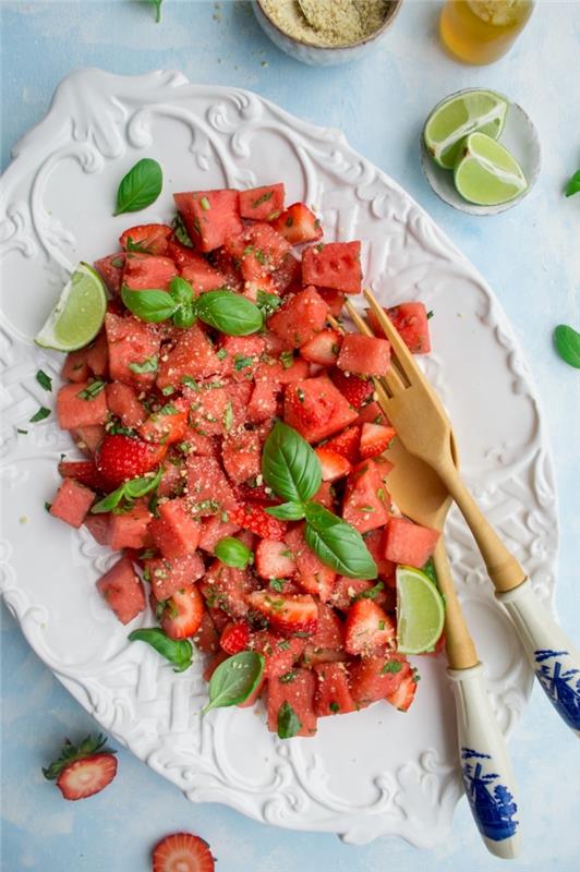 jednoduchý a originálny letný šalát z melónu, jahôd, čerstvej mäty a vegánskeho parmezánu, oblečený v citrónovej šťave a javorovom sirupe