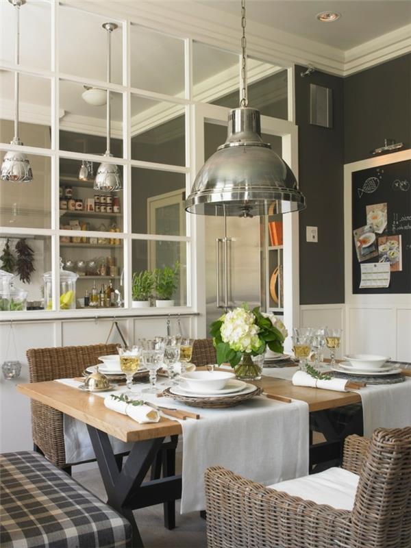 kuchyňa a jedáleň vo vidieckom štýle, rustikálny drevený stôl a stoličky, veľké závesné žiarovky