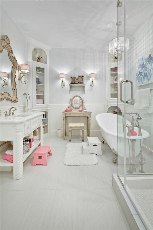 helt vitt badrum med rosa detaljer, ovalt badkar, kromkran, vit matta, antikt konsolbord, barockspegel, rosa vägglampor
