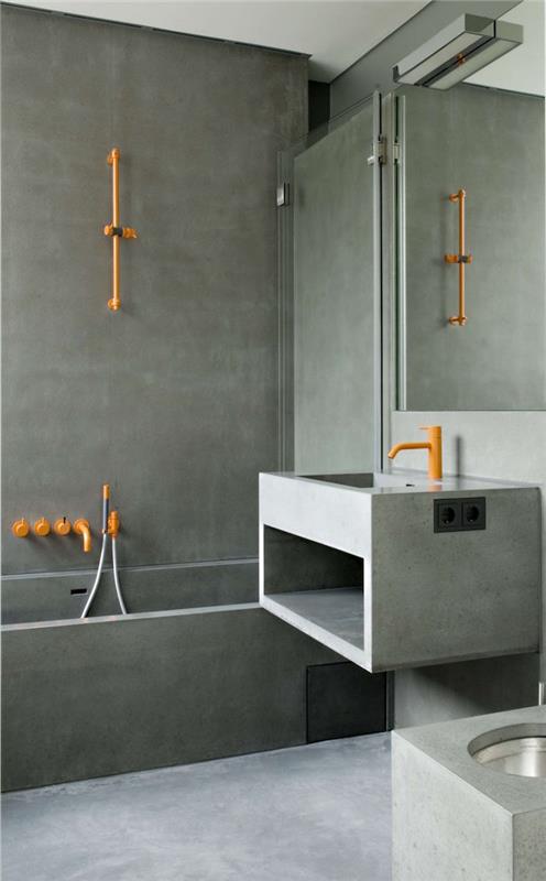 bezbariérový sprchovací kút z voskovaného betónu na modernej stene kúpeľne a v prevedení s cementovým drezom a oranžovou kovovou inštaláciou