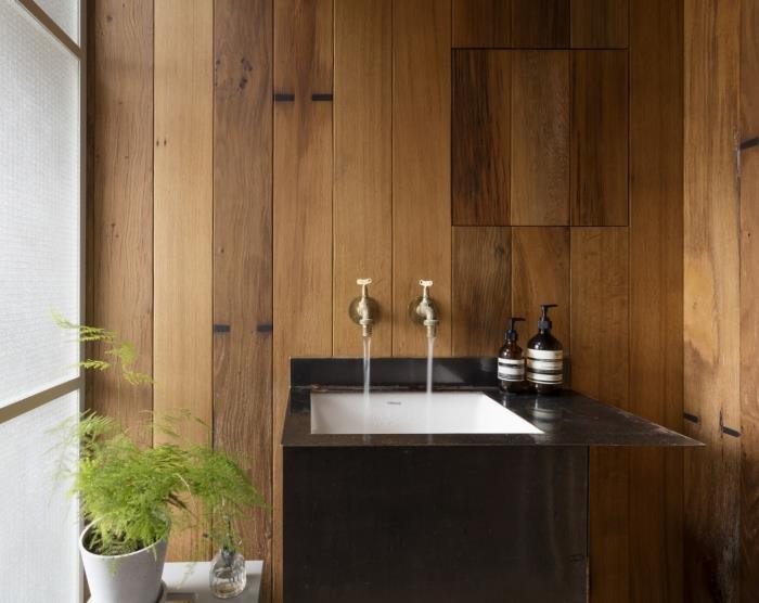 Drevený dizajn kúpeľne v japonskom štýle, malá kúpeľňová dekorácia s drevenými stenami a umývadlom v bielej a čiernej farbe