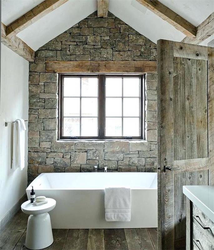 zrekonštruovaná stará kúpeľňa so starými sivými kameňmi, parketovou podlahou a starými drevenými dverami