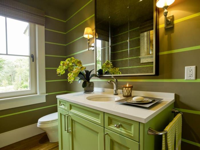zelená dekorácia WC, okrúhle umývadlo, zelená umývadlová skrinka, dve svietniky, zrkadlo, biele okno